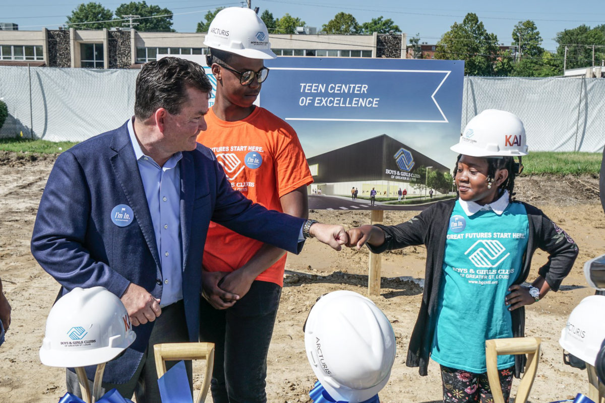 A child and adult fist bumping at Boys & Girls Club ceremony