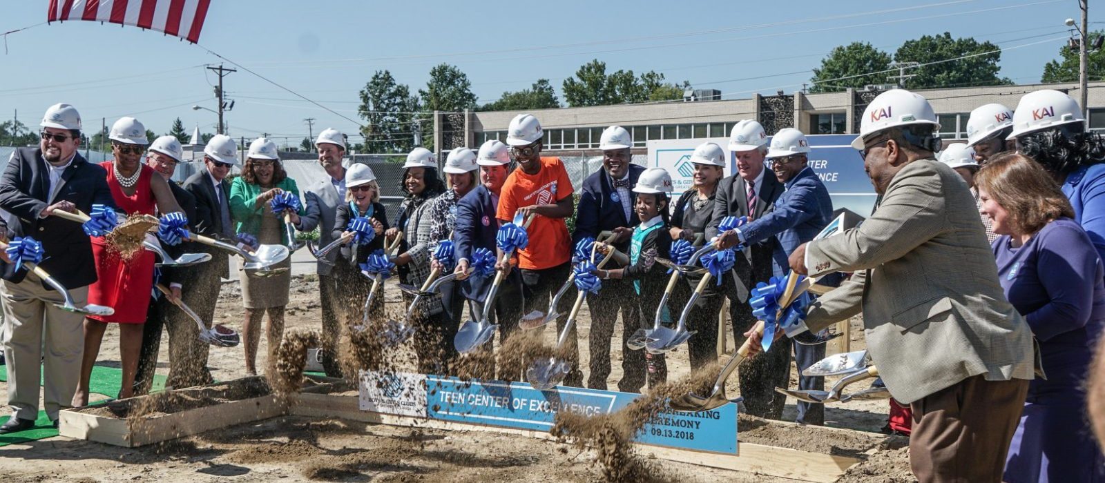 Attendees of the Boys & Girls Clubs ceremony shoveling dirt together